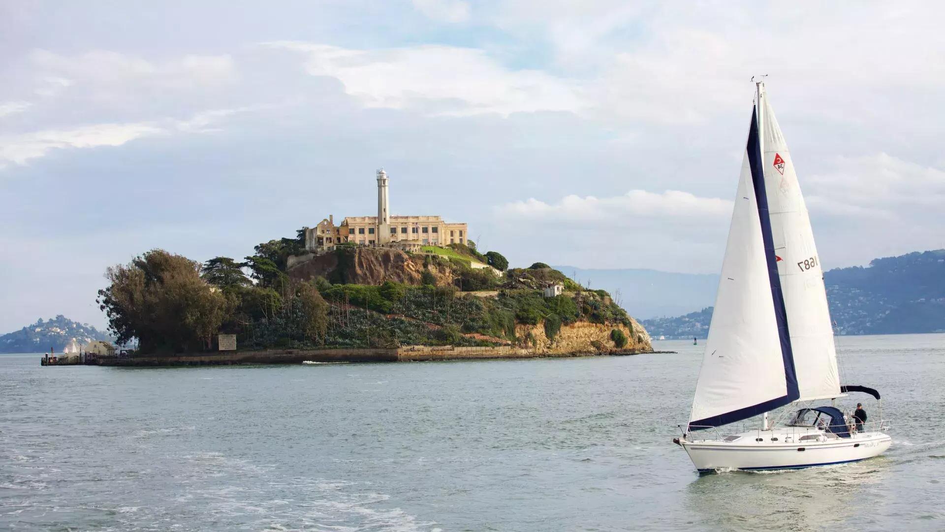 A sailboat passes in front of 阿尔卡特拉斯岛 Island in San Francisco.
