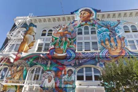 Un colorido mural a gran escala cubre el costado del Edificio de Mujeres en el 使命地区 de 贝博体彩app.